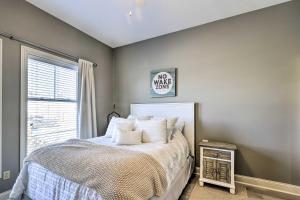 a bedroom with a bed and a window at Dtwn Ludington Condo Balcony, Walk To Beach! in Ludington