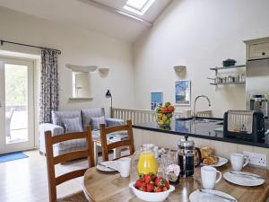 uma cozinha e sala de estar com uma mesa com frutas em Yennadon Barn em Totnes