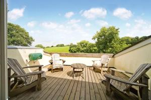 a deck with chairs and a table and a table and chairs at Yennadon Barn in Totnes