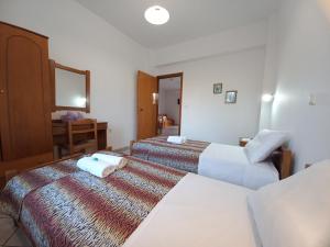 プラタニアスにあるBabis Apartmentsのベッド2台と鏡が備わるホテルルームです。