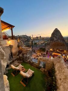 a rooftop patio with chairs and a view of the city at Castle Cave Hotel in Göreme