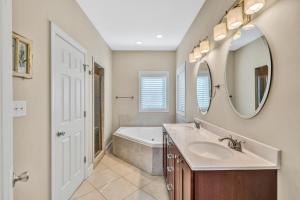 een badkamer met een wastafel, een bad en een spiegel bij Osprey Cove in Moneta