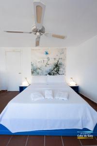 a bedroom with a white bed with two pillows at CASA ESCUELA PLAYA in San José