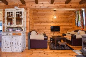 een woonkamer met twee banken en een tv in een huisje bij Holiday Home Jakov in Kolašin