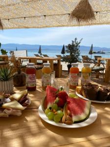 - une table avec des assiettes de nourriture et des fruits dans l'établissement Palm Beach, à Ajaccio