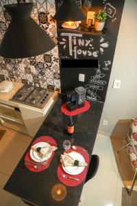a kitchen counter with two red plates and a stove at Casa Pequena, Completa e Aconchegante - Tiny House in Palmas