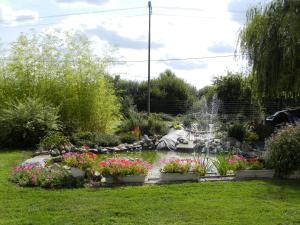 un jardín con una fuente y flores en un patio en Chambres d'Hôtes La Quèrière, en Mur-de-Sologne