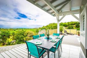 patio con tavolo e sedie su una terrazza di Magnifique villa piscine, vue mer, 8 km plages a Le François