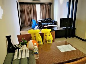 FHS Water Themepark Resort Melaka Town City Tengah في ميلاكا: غرفة معيشة مع طاولة وأريكة