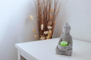 uma estátua de um monge segurando um cesto de cebolas verdes em Paradis Prado furnished apartment em Marselha