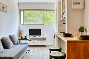 uma sala de estar com um sofá e uma televisão em Paradis Prado furnished apartment em Marselha