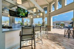 a patio with chairs and a bar with a flat screen tv at Excellent Resort Free/ Makin Memories / 4 Beds in Kissimmee