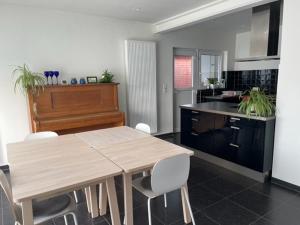 a kitchen with a wooden table and a piano at Fokus PraktijkHuis in Dessel