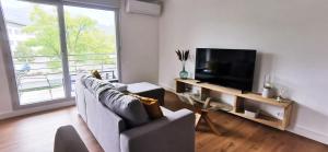 ein Wohnzimmer mit einem Sofa und einem Flachbild-TV in der Unterkunft The select's of Montbonnot - Inovallée #DY in Montbonnot-Saint-Martin