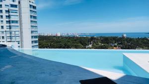 a swimming pool on the roof of a building at Apartamento Acapulco Roosevelt in Punta del Este