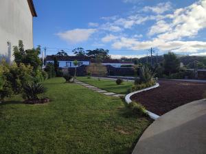 podwórko z trawnikiem i chodnikiem w obiekcie Basalto Negro AL w mieście Angra do Heroísmo