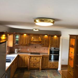 uma cozinha com armários de madeira e um tecto em Stunning 5-Bed House in Clones em Clones