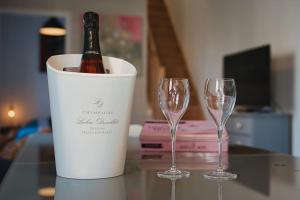 butelkę wina w wiadrze obok dwóch kieliszków wina w obiekcie L'effervescence w mieście Dormans