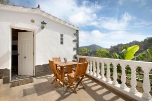 a patio with a table and chairs on a balcony at El Sarmiento in Tegueste
