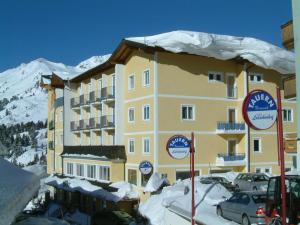 a large yellow building with snow on top of it at Hotel Solaria in Obertauern