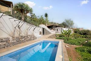 a swimming pool in front of a house at La Bodega de Julián in Tegueste