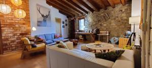 een woonkamer met een bank en een tafel bij Alberg Rural La Rectoria de Pedra in Bellver de Cerdanya 