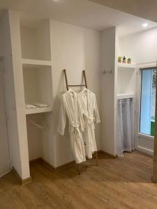 una stanza con camicie bianche appese a un muro di Superbe suite avec jacuzzi patio et sauna a La Ciotat