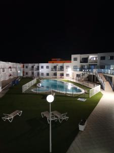 Costa Calma Sun & Pool Apartment في كوستا كالما: مسبح في وسط مبنى في الليل