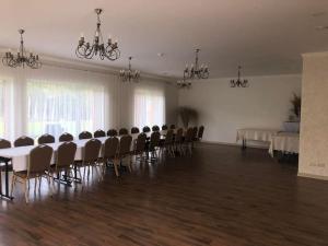 een grote kamer met een lange tafel en stoelen bij Marių įlanka in Marijampolė