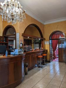 un bar en un restaurante con una lámpara de araña en Hotel Montecarlo, en Castellanza