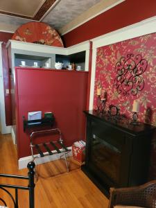 een woonkamer met een open haard en een rode muur bij Prairie House Manor Bed and Breakfast in De Smet