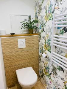 a bathroom with a toilet and a plant on the wall at La Tiny Blue - maison insolite pour 2 - sans Tv in Saint-Aignan