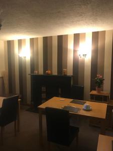a dining room with a table and a striped wall at Roselodge Guest House in Aberdeen