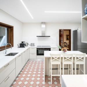 a white kitchen with white cabinets and white appliances at Santiago Family House in Sever do Vouga