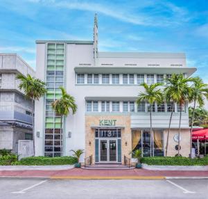 een wit gebouw met palmbomen ervoor bij Kent Hotel in Miami Beach