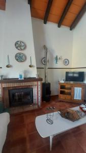 salon z kominkiem i białym stołem w obiekcie Chalet la Huerta 2 amplios jardines barbacoa y WiFi w mieście Conil de la Frontera