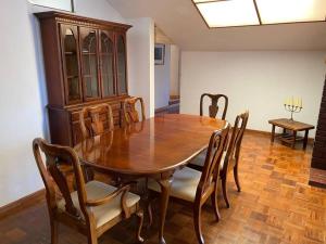uma sala de jantar com uma mesa de madeira e cadeiras em Apartamento de lujo con jardines paisajísticos em La Paz