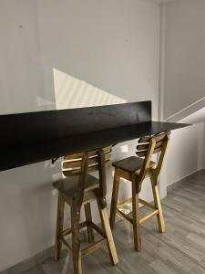 una mesa con 2 sillas y una encimera negra en Aparta estudio, en Filandia