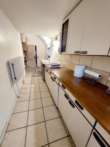 a kitchen with white cabinets and a tiled floor at Koronkowa Chatka w Beskidach in Istebna