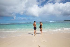 a man and a woman standing on the beach at Constance Le Chaland IKO Mauritius in Blue Bay