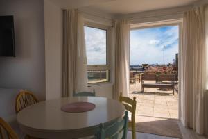 a dining room with a table and a view of the ocean at 1 Quayside Court in Swanage