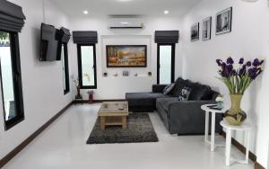 a living room with a black couch and a table at Private Pool Villa with Jacuzzi at Royal Park Village - Walk to the Beach - MAX 3 ADULT MALES in Jomtien Beach