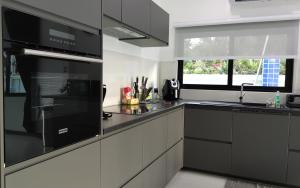 a kitchen with black and white appliances and a window at Private Pool Villa with Jacuzzi at Royal Park Village - Walk to the Beach - MAX 3 ADULT MALES in Jomtien Beach