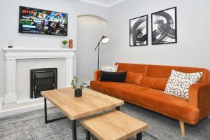 a living room with a couch and a fireplace at Hanford Apartments by YourStays in Stoke on Trent