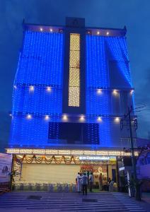 um edifício azul com pessoas à frente dele em Sri Aswin Grand em Nāmakkal