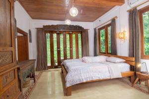 - une chambre avec un lit et une grande fenêtre dans l'établissement Dream Village, à Jarakan