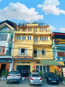 a yellow building with cars parked in front of it at Minh Hưng Hostel in Sa Pa