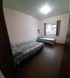 a bedroom with two beds and a window at Casa do Porto - a 600m do Mar e da Lagoa in Florianópolis +16 photos