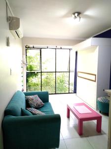 a living room with a green couch and a table at Luminoso monoambiente con cochera propia dentro del edificio in La Plata