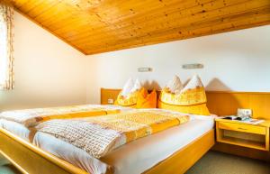 a bedroom with two beds and a wooden ceiling at Haus Kathrin in Dorfgastein